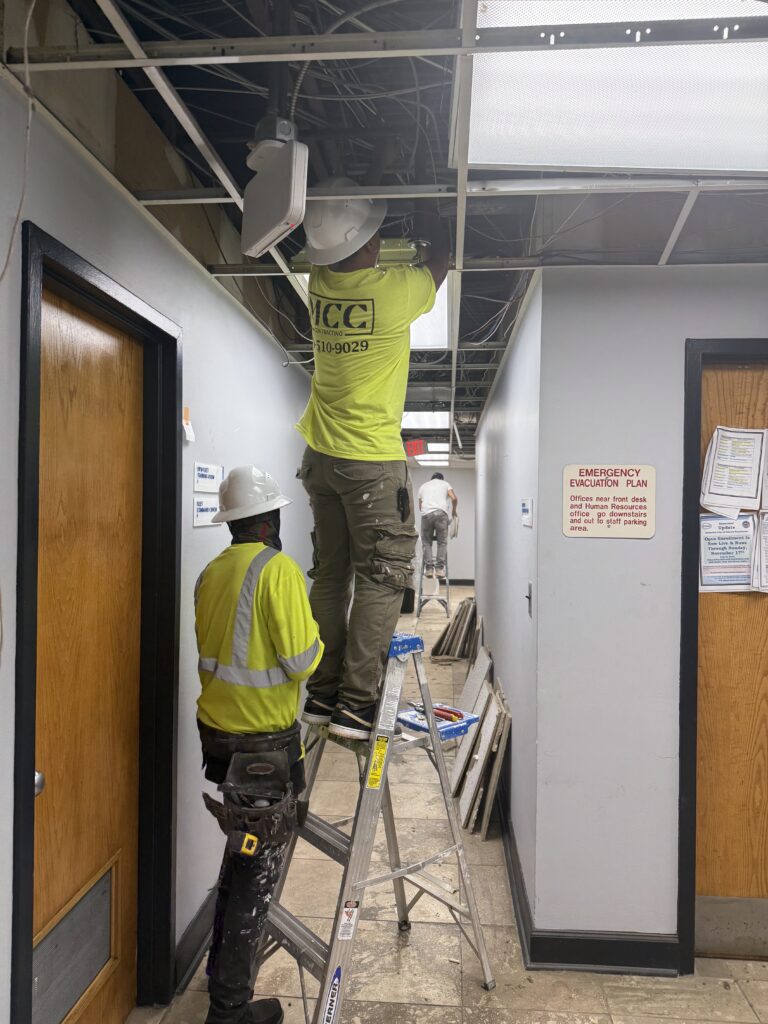 Workers inspecting ceiling in a commercial building