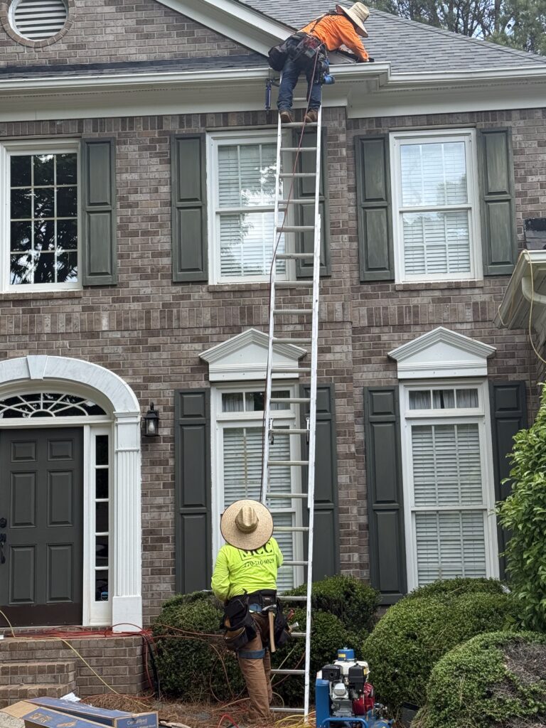 Worker inspecting house exterior, roof and storm damage repair North Georgia
